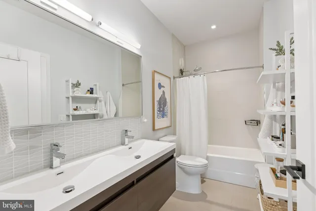 a bathroom with a double vanity sink toilet tub and shower