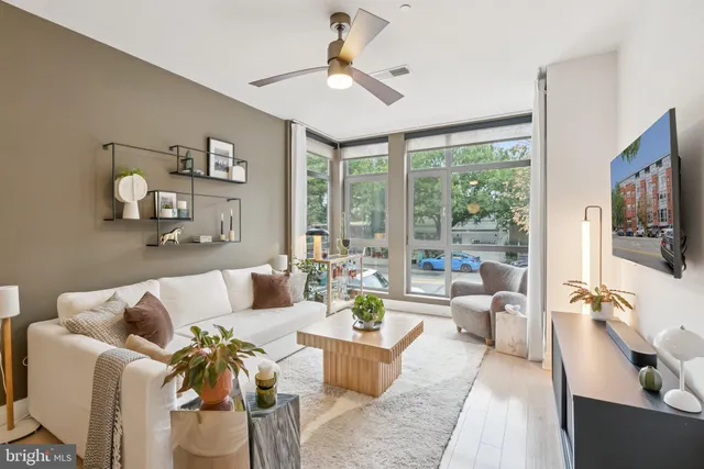 a living room with furniture ceiling fan and a flat screen tv