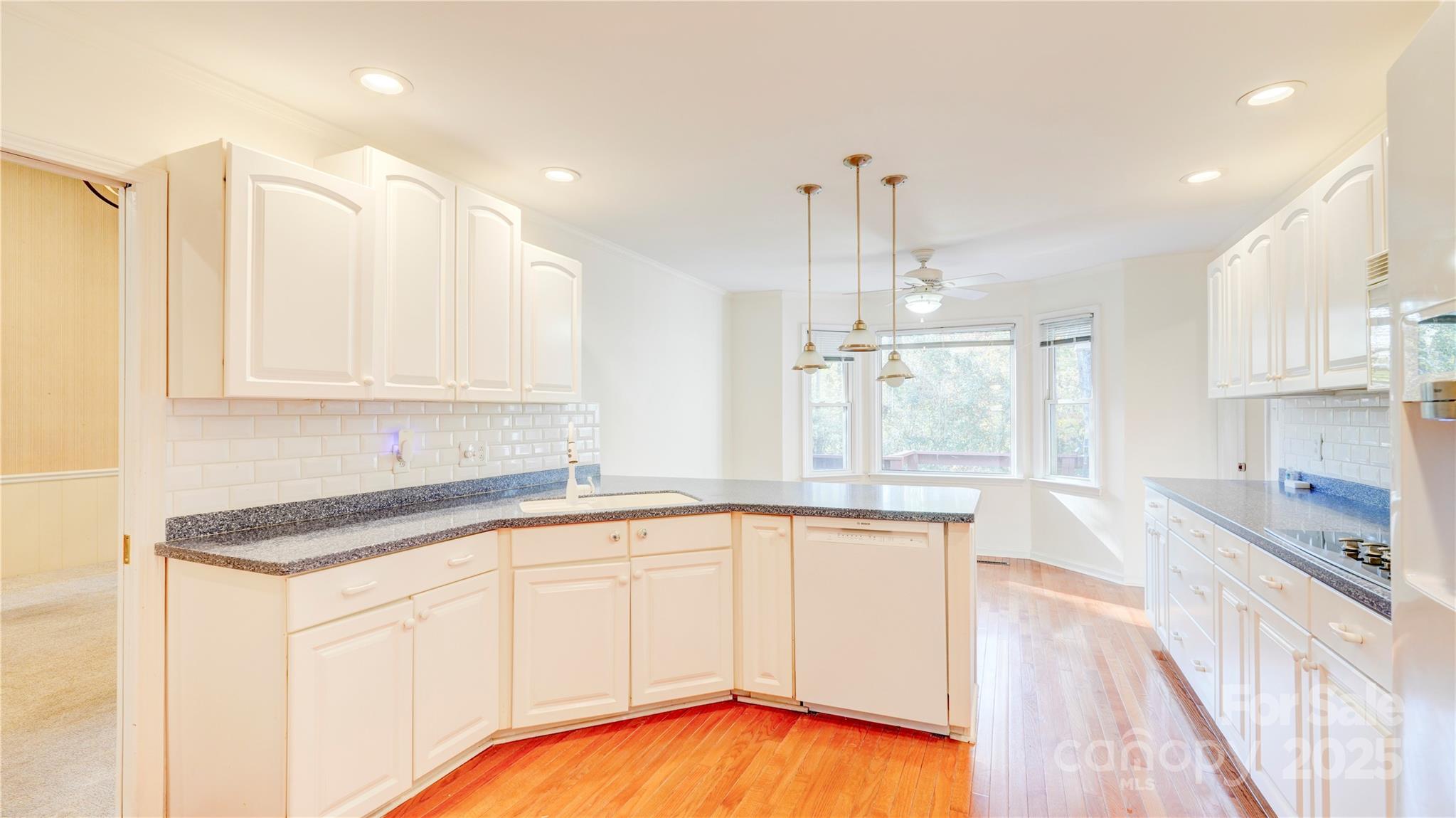 1535 Cripple Creek Road Kannapolis, NC 28081 - Photo 17 of 40 a kitchen with stainless steel appliances granite countertop a sink a stove a refrigerator and island with wooden floor