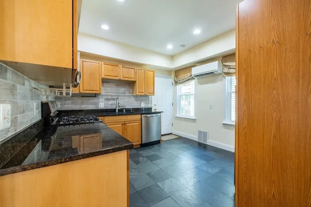 a kitchen with granite countertop a sink and a refrigerator