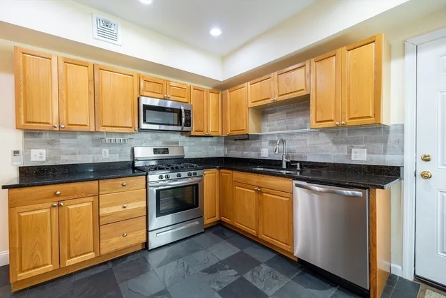 a kitchen with stainless steel appliances granite countertop a stove sink and microwave