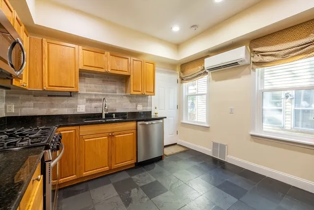 a kitchen with stainless steel appliances granite countertop a stove a sink and a microwave