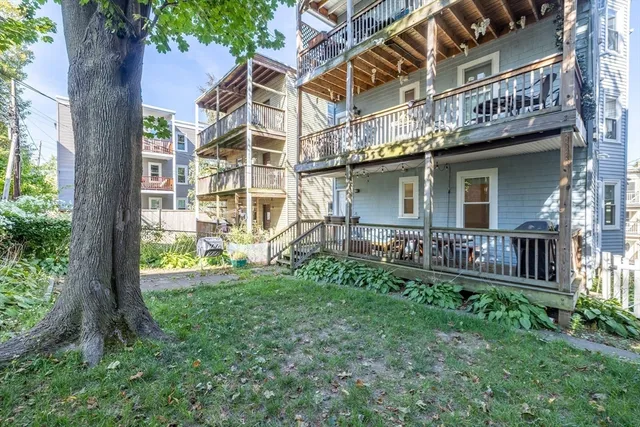 a view of a house with a yard and a wooden deck