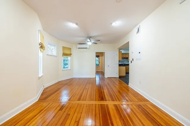 a view of empty room with wooden floor
