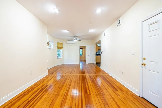 a view of empty room with wooden floor