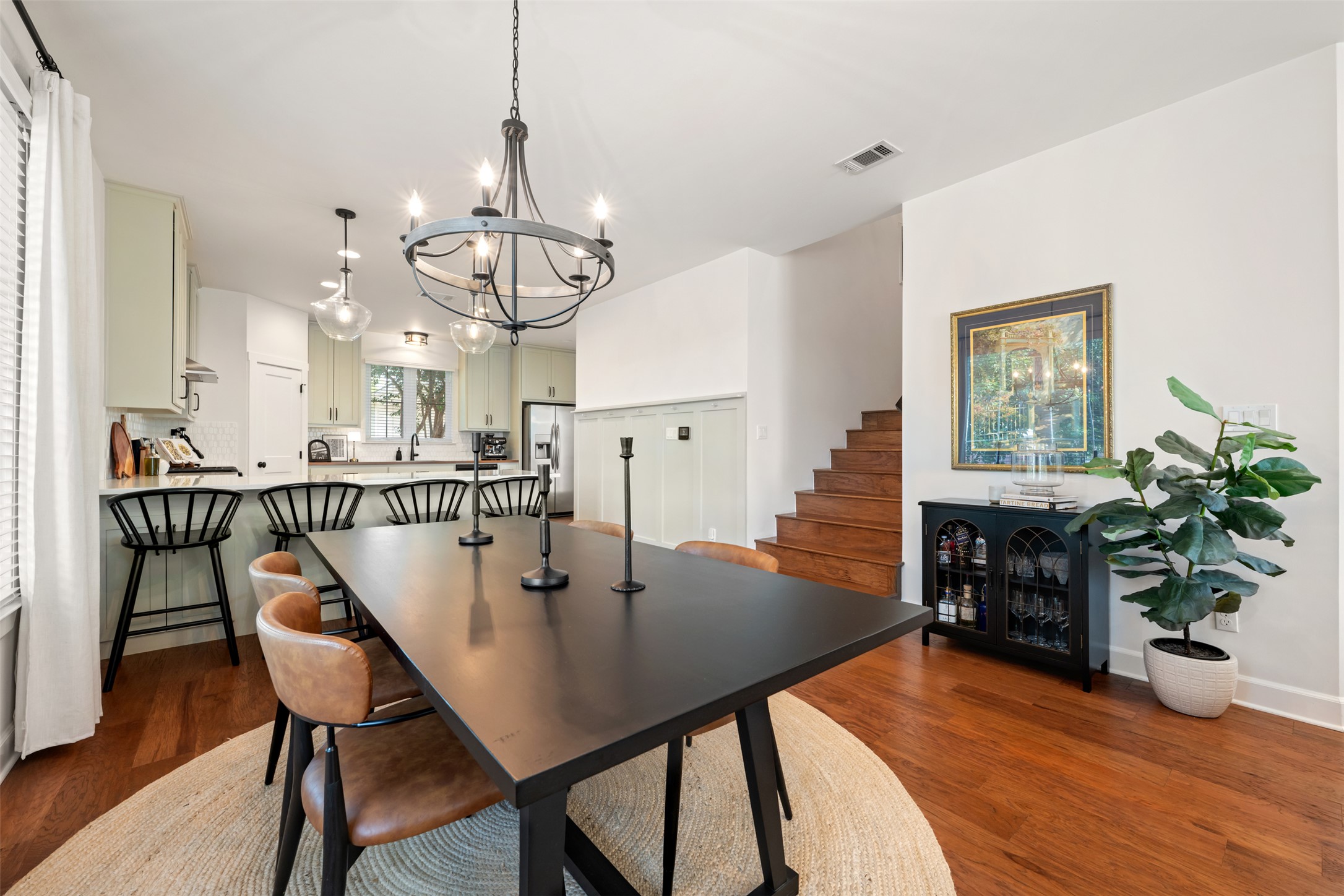 1301 West Street Georgetown, TX 78626 - Photo 9 of 40 Hardwood flooring extends from the dining area to the kitchen, creating a cohesive and inviting space.