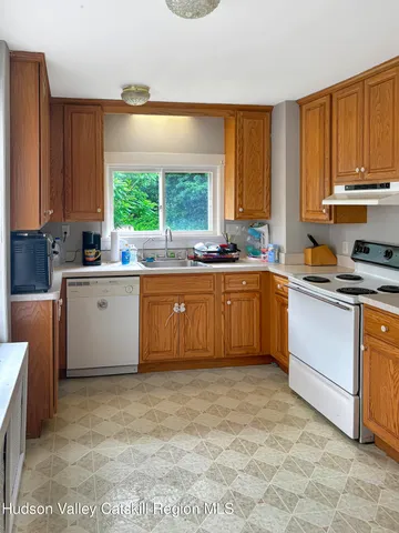 a large kitchen with a window a sink and cabinets