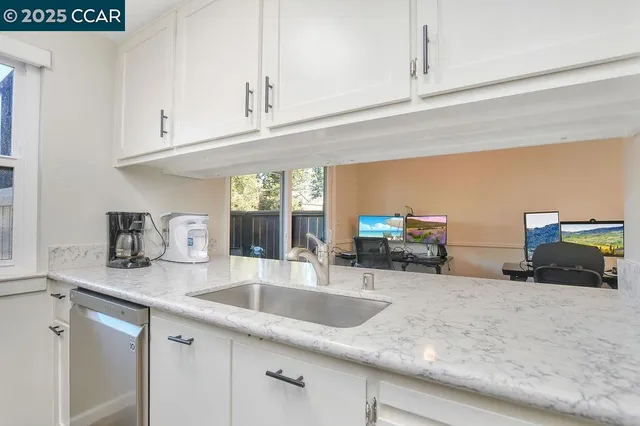 a kitchen with stainless steel appliances granite countertop a sink and white cabinets