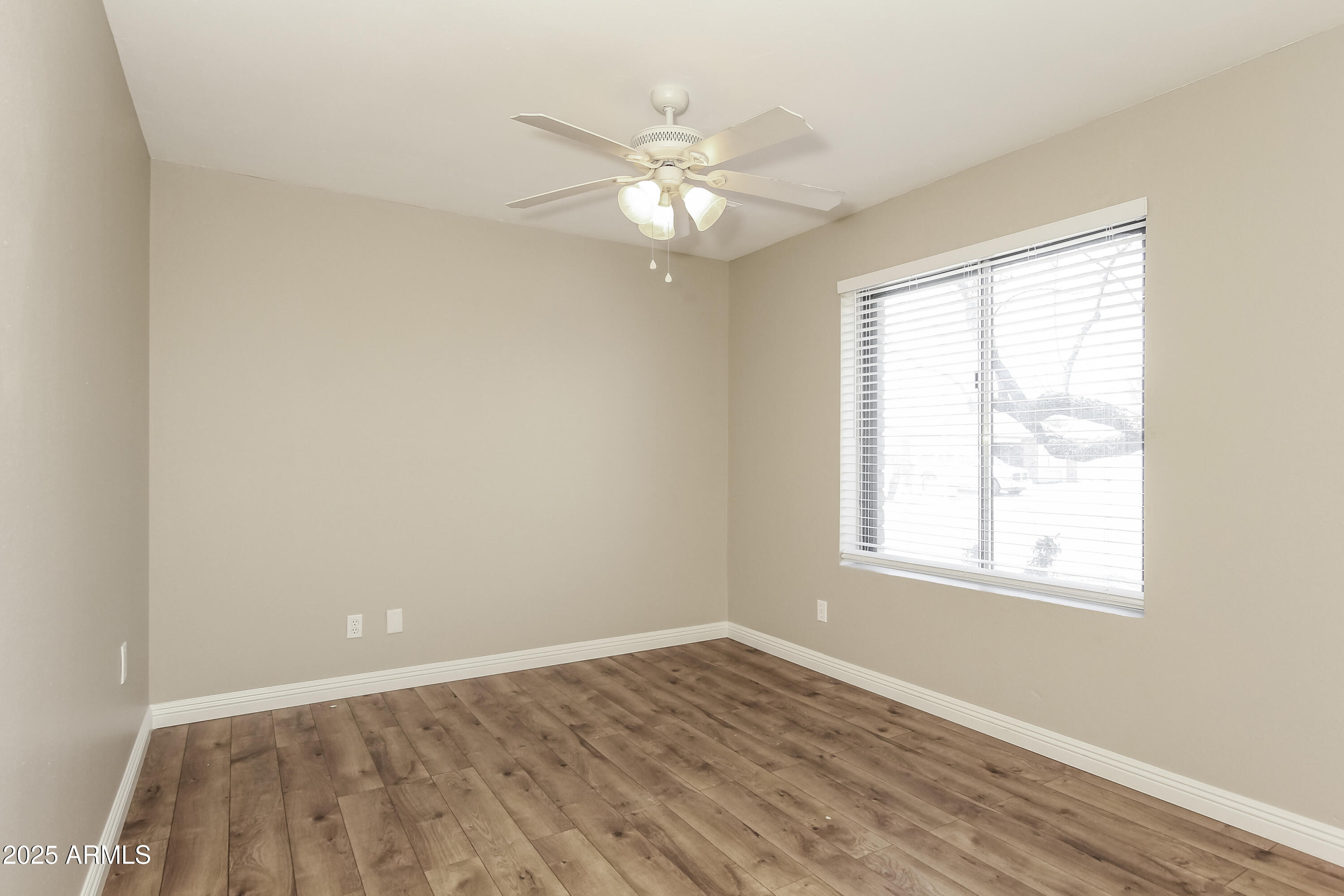 2839 West Wagoner Road Phoenix, AZ 85053 - Photo 11 of 15 an empty room with wooden floor fan and windows