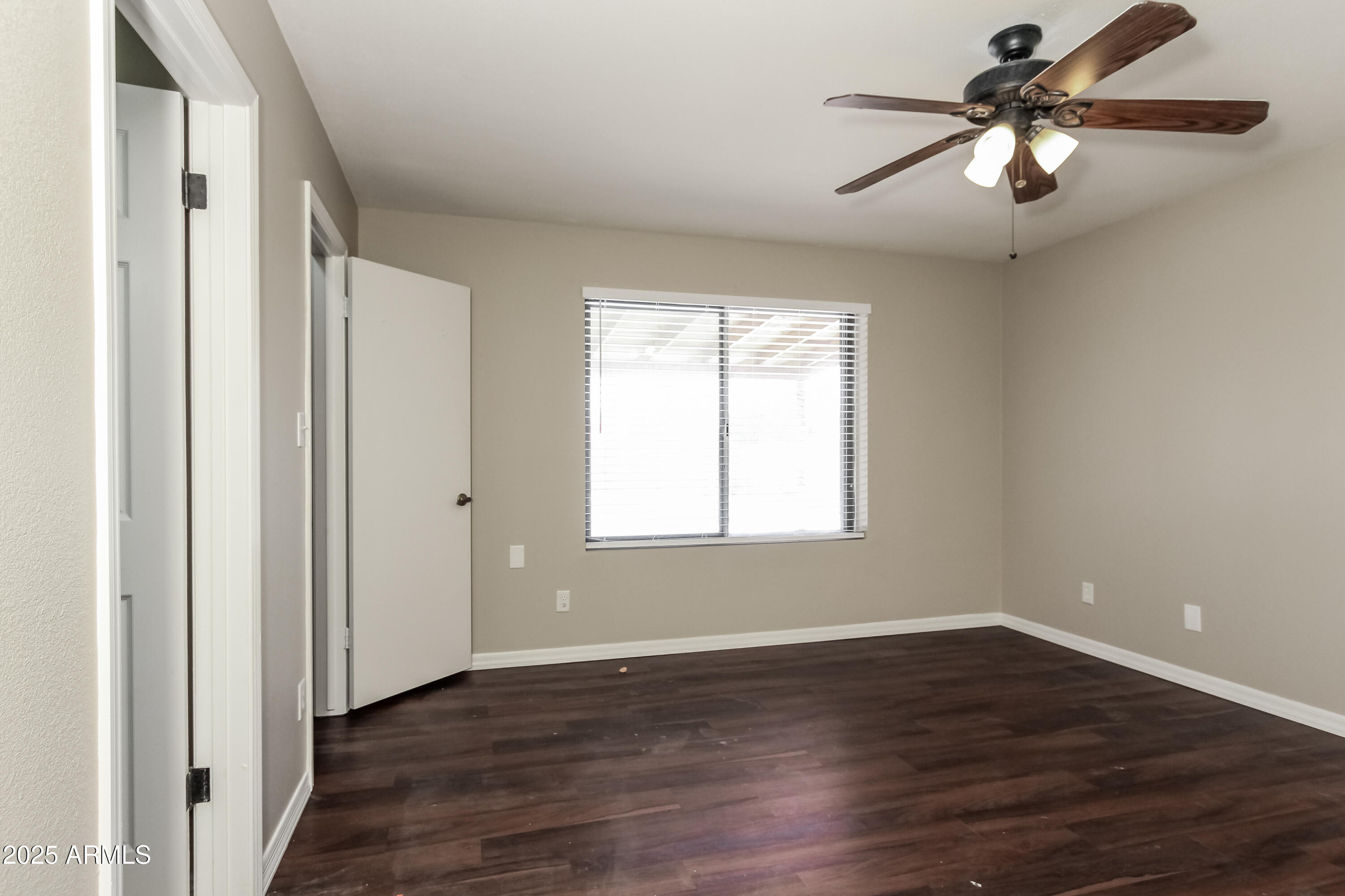 2839 West Wagoner Road Phoenix, AZ 85053 - Photo 12 of 15 an empty room with wooden floor chandelier fan and windows