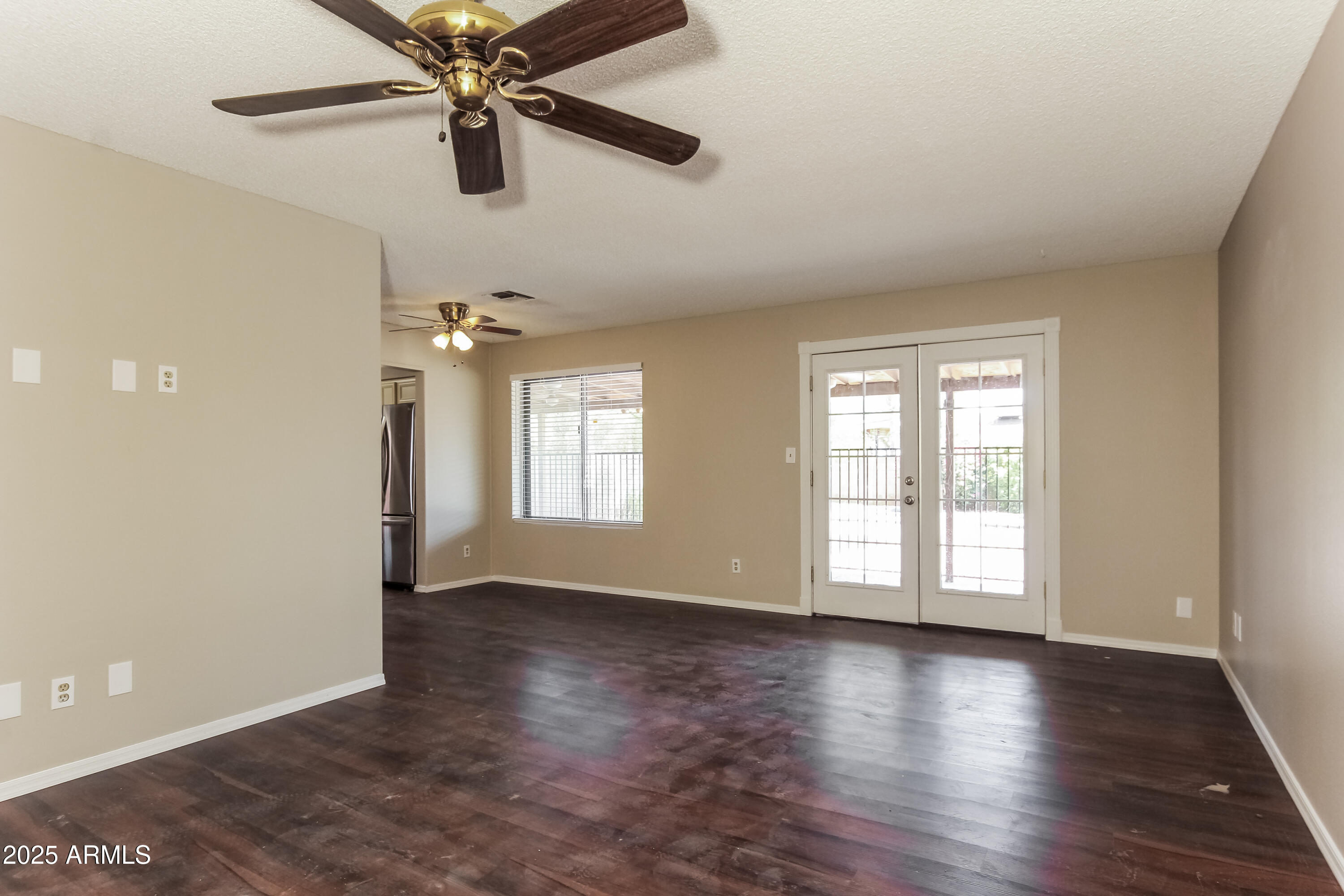 2839 West Wagoner Road Phoenix, AZ 85053 - Photo 3 of 15 an empty room with wooden floor chandelier fan and windows