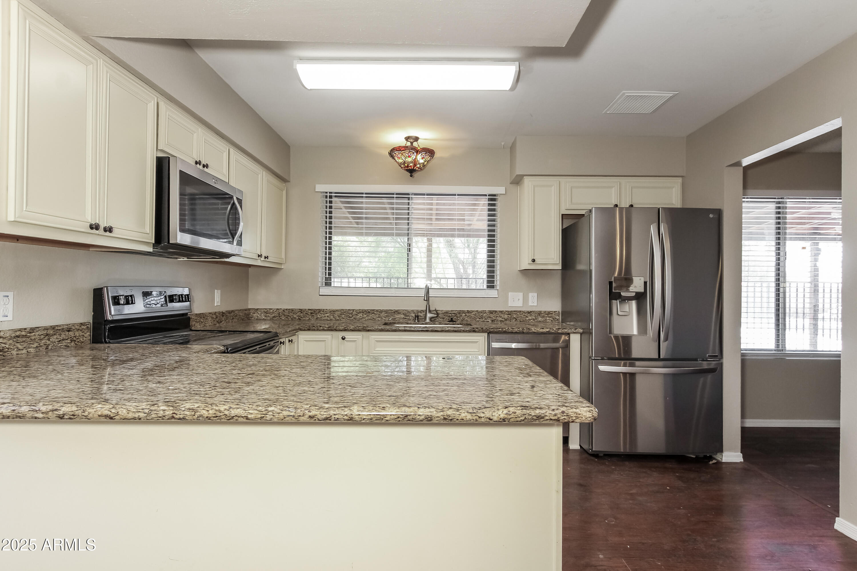 2839 West Wagoner Road Phoenix, AZ 85053 - Photo 5 of 15 a kitchen with granite countertop a refrigerator stove microwave and sink
