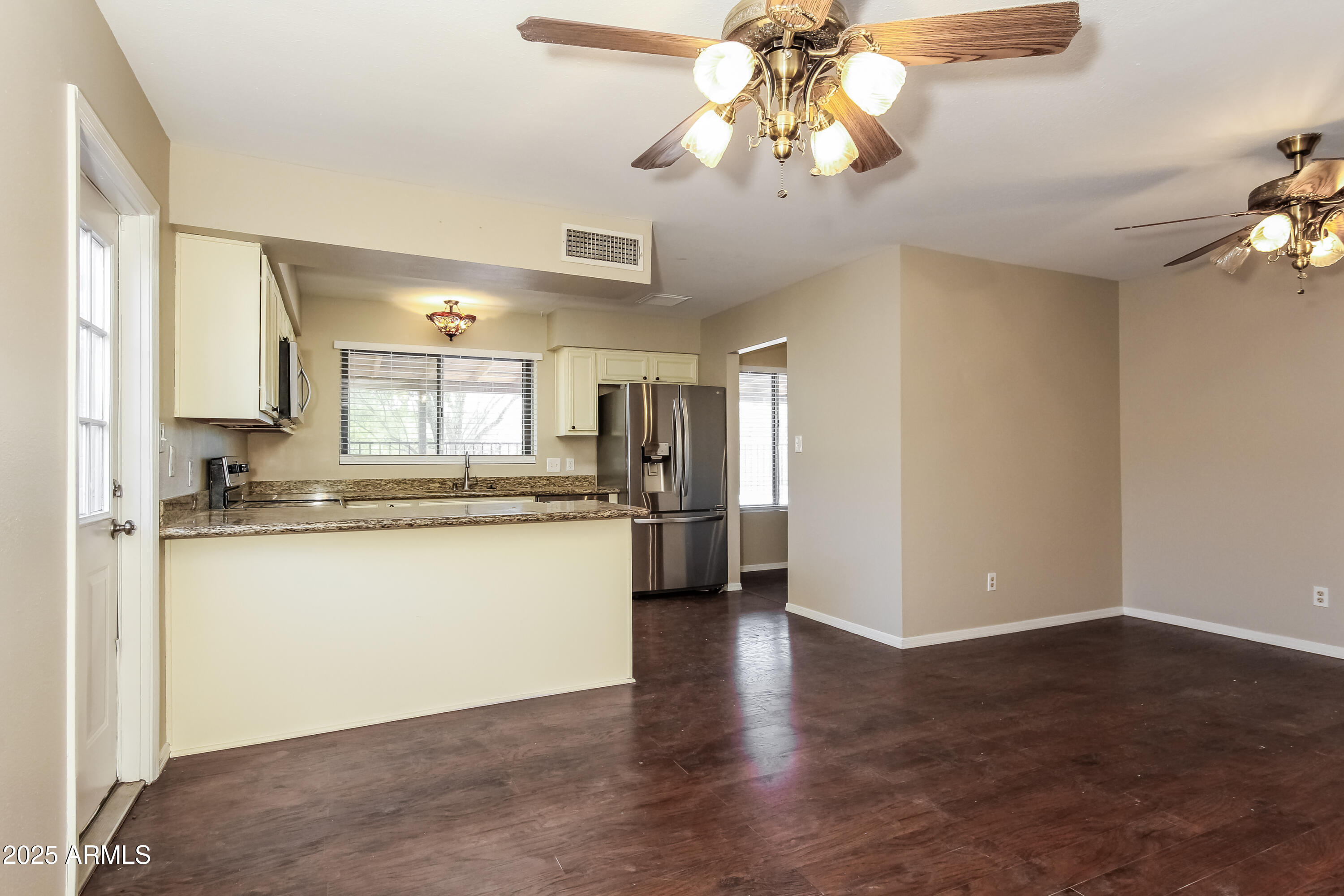 2839 West Wagoner Road Phoenix, AZ 85053 - Photo 6 of 15 a kitchen with stainless steel appliances granite countertop a refrigerator a sink dishwasher a stove and white cabinets with wooden floor