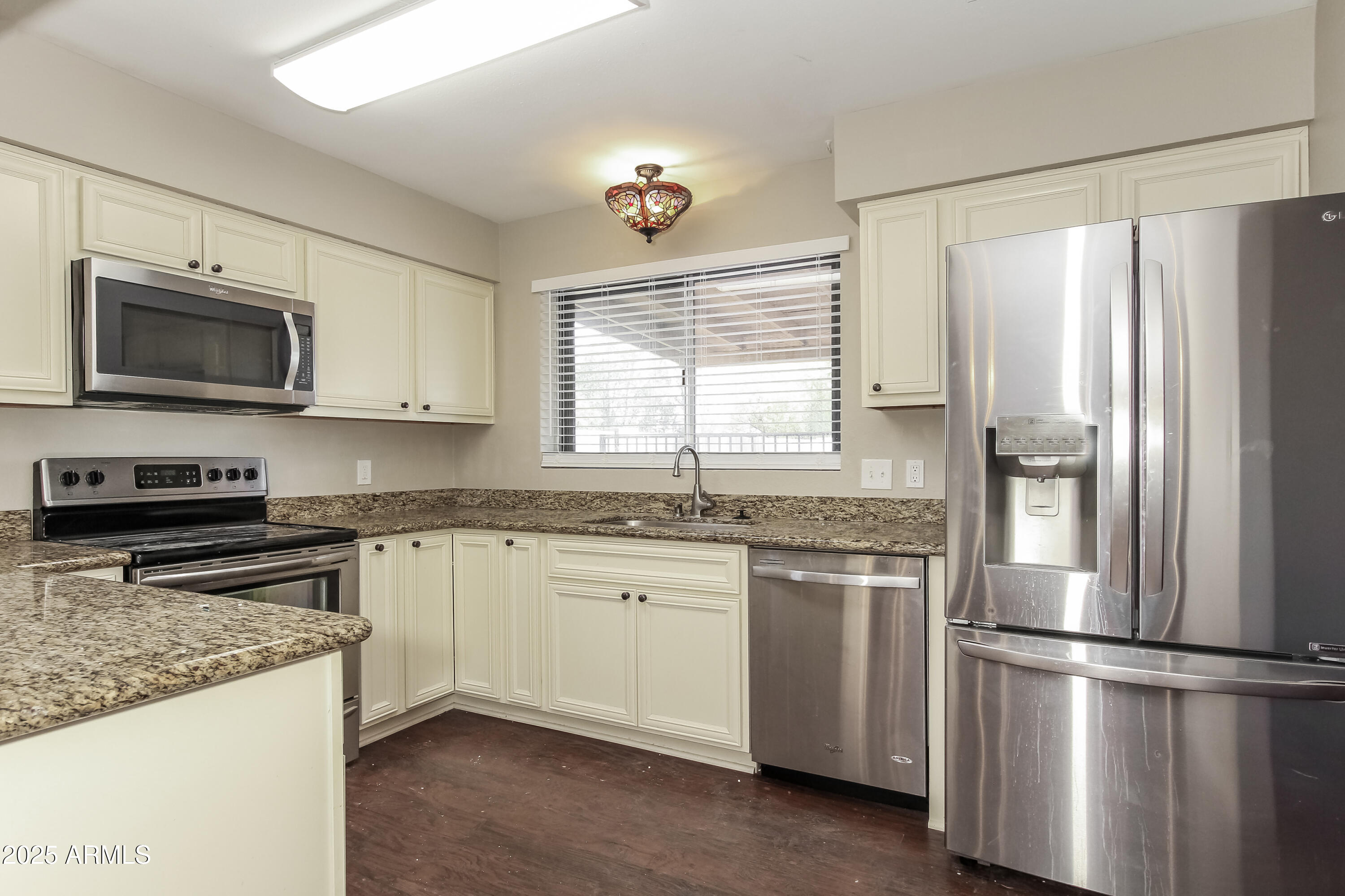 2839 West Wagoner Road Phoenix, AZ 85053 - Photo 7 of 15 a kitchen with granite countertop white cabinets and stainless steel appliances