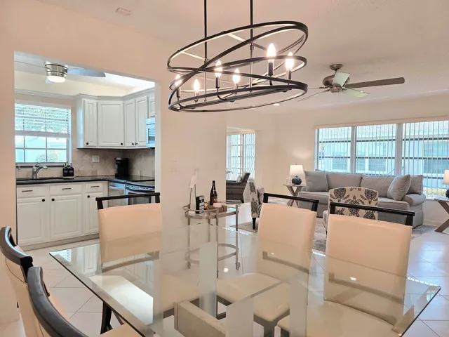a kitchen with a table chairs and white cabinets