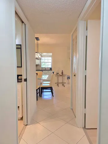 a view of a hallway with bathroom and a glass door