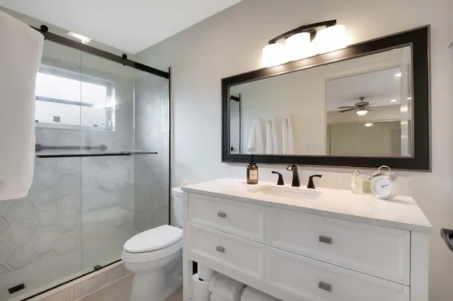 a bathroom with a double vanity sink mirror and toilet