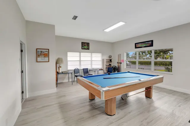 a room with pool table and windows