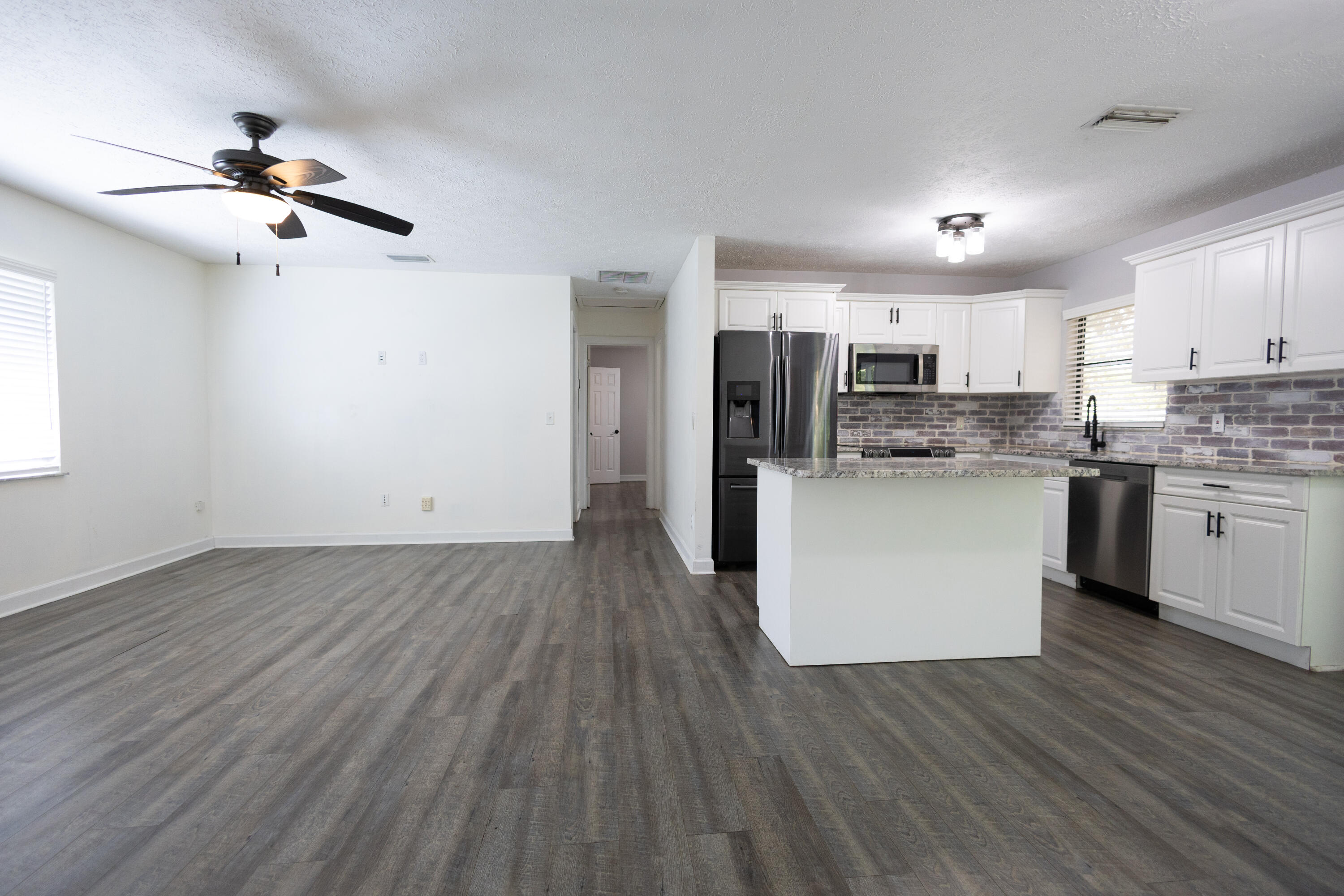 1914 Southwest Beauregard Street Port St. Lucie, FL 34953 - Photo 11 of 23 a view of kitchen with refrigerator microwave and wooden floor