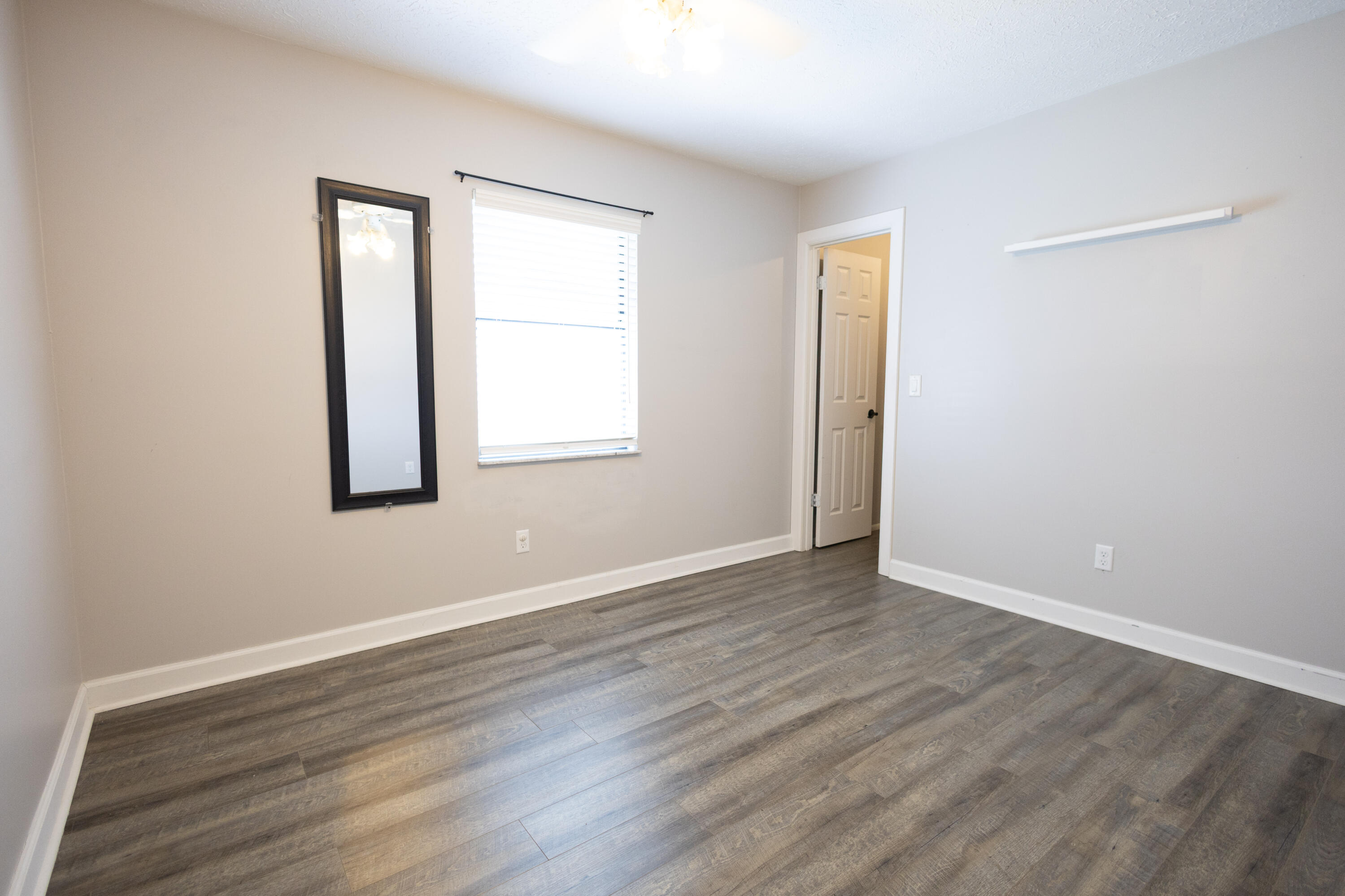 1914 Southwest Beauregard Street Port St. Lucie, FL 34953 - Photo 17 of 23 an empty room with wooden floor and windows