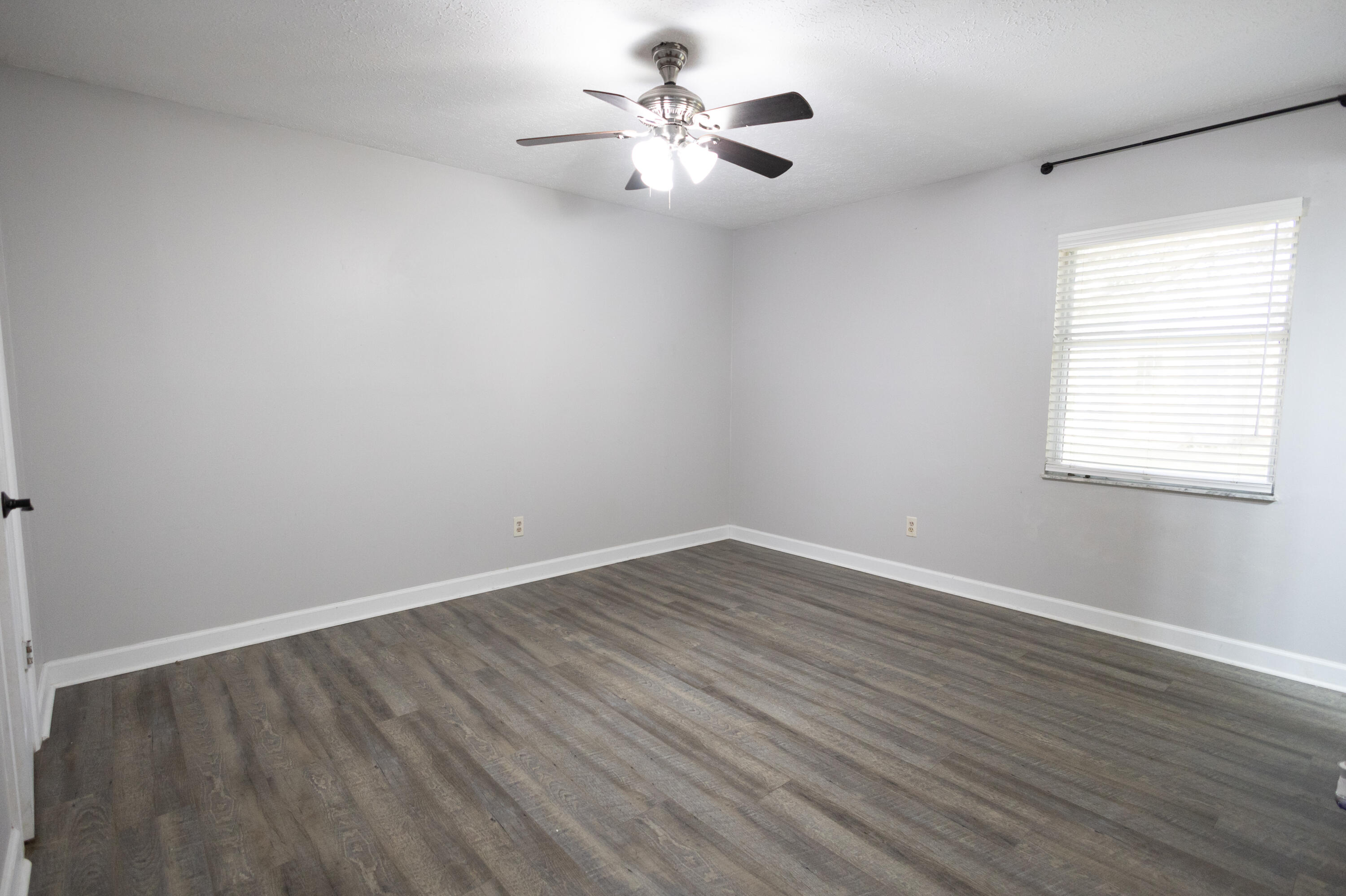 1914 Southwest Beauregard Street Port St. Lucie, FL 34953 - Photo 20 of 23 a view of an empty room with wooden floor and a window