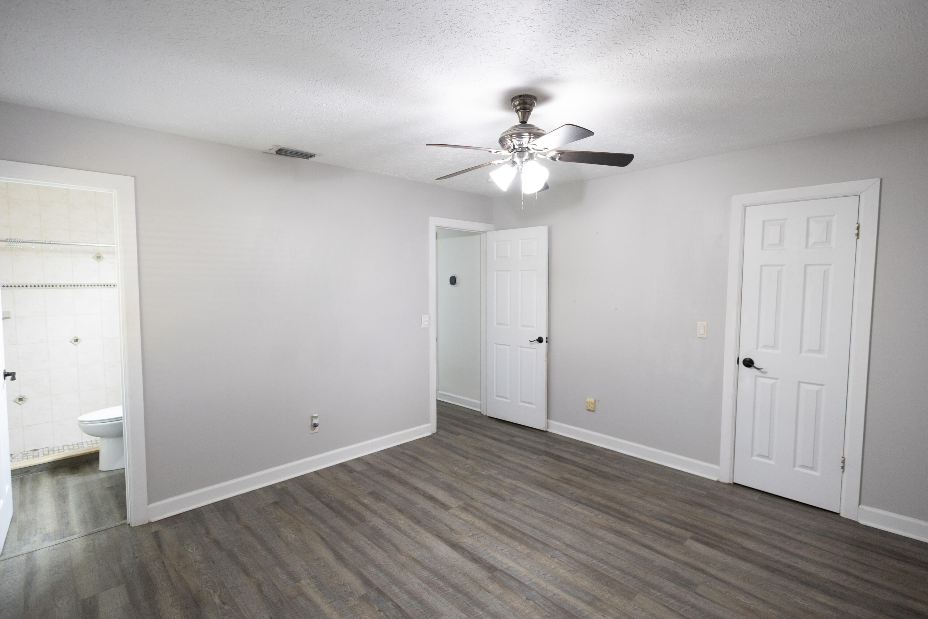 1914 Southwest Beauregard Street Port St. Lucie, FL 34953 - Photo 21 of 23 an empty room with wooden floor and ceiling fan