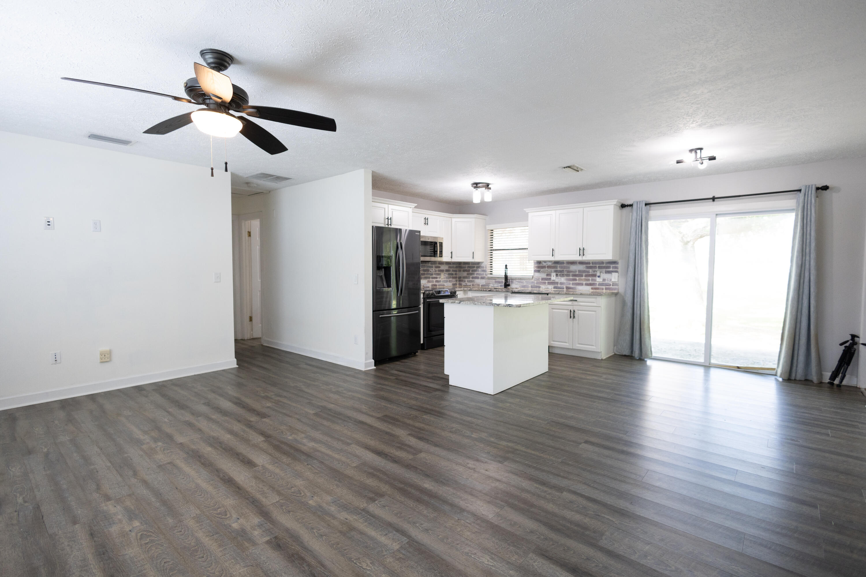 1914 Southwest Beauregard Street Port St. Lucie, FL 34953 - Photo 6 of 23 a view of kitchen with refrigerator microwave and stove with wooden floor