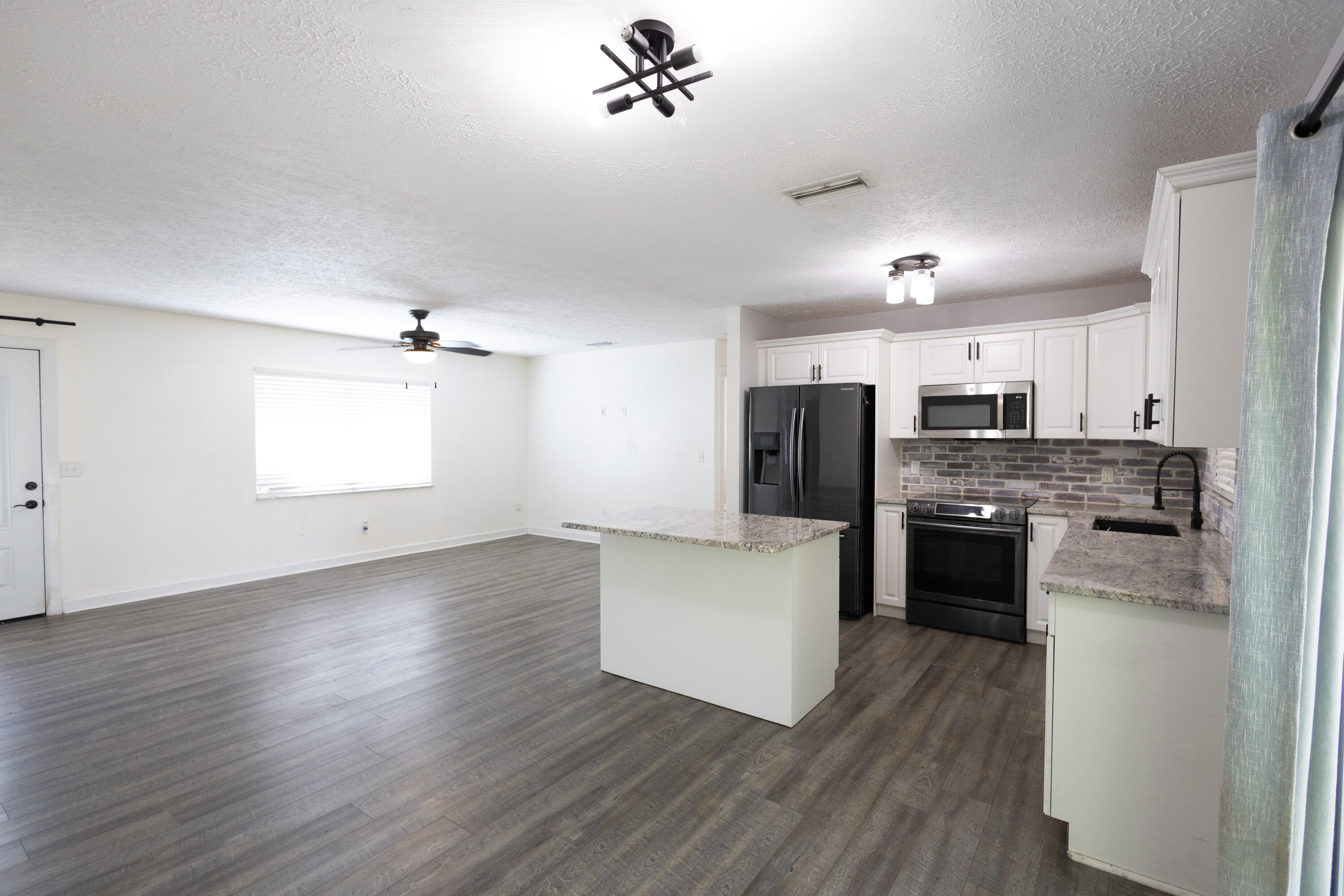 1914 Southwest Beauregard Street Port St. Lucie, FL 34953 - Photo 7 of 23 a kitchen with a refrigerator and a stove top oven