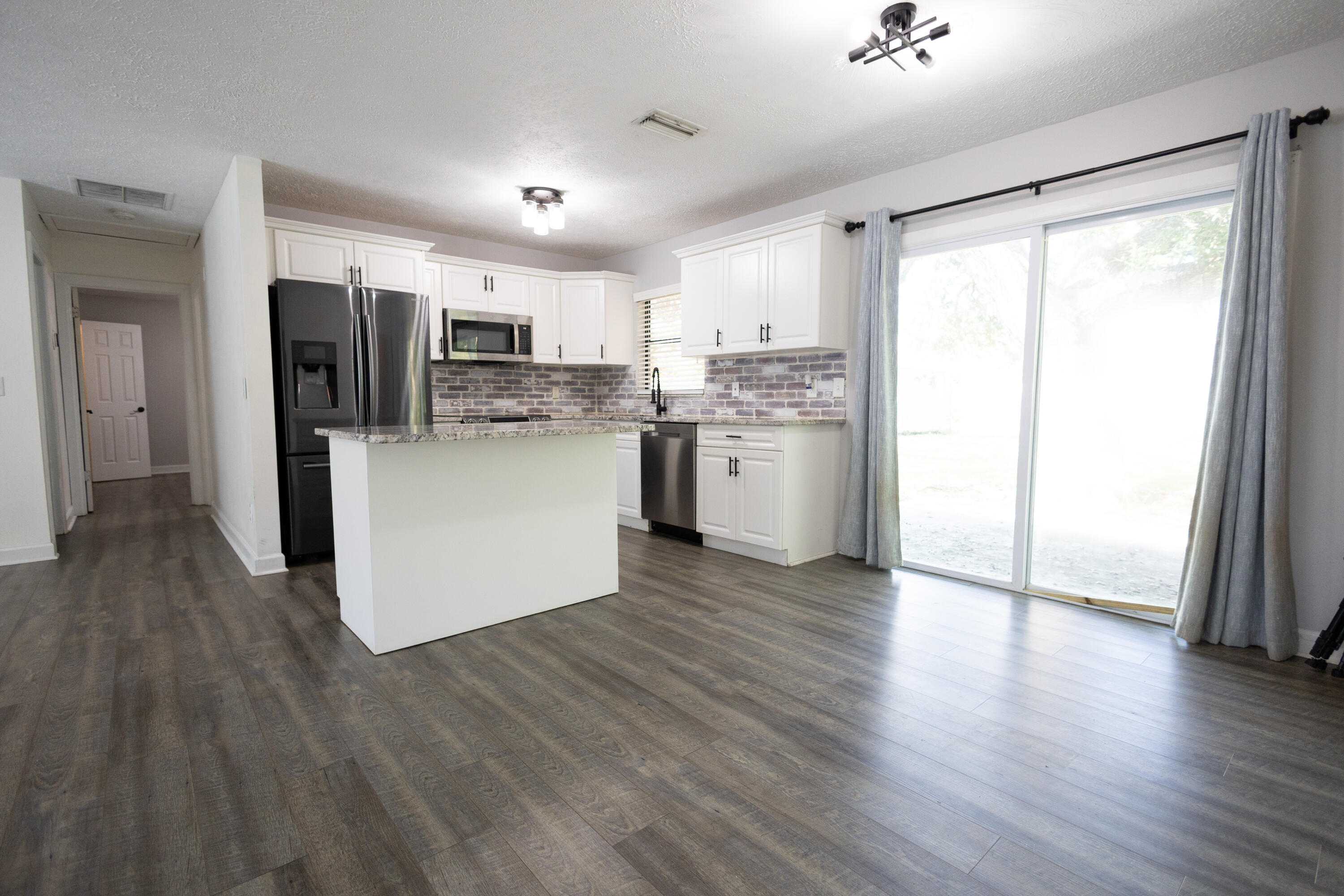 1914 Southwest Beauregard Street Port St. Lucie, FL 34953 - Photo 10 of 23 a kitchen with stainless steel appliances granite countertop a refrigerator and a stove top oven