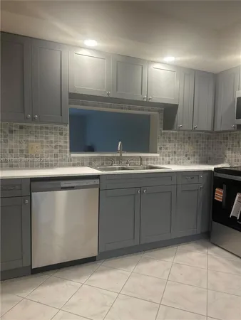 a kitchen with stainless steel appliances granite countertop a sink and a stove