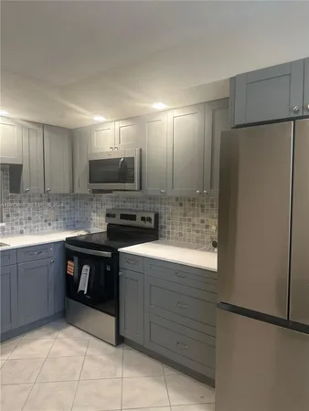 a kitchen with kitchen island sink refrigerator and cabinets