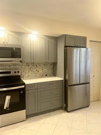 a kitchen with stainless steel appliances granite countertop a refrigerator and a sink