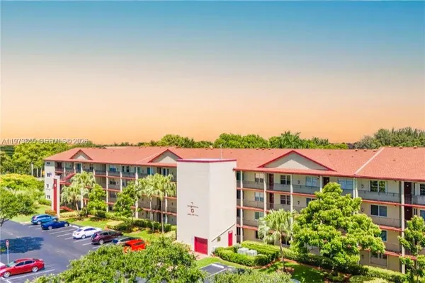a view of a white house with a yard and potted plants
