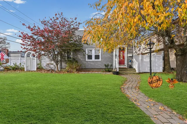 a view of a house with backyard and a tree