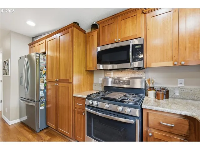 a kitchen with stainless steel appliances granite countertop a refrigerator stove and microwave
