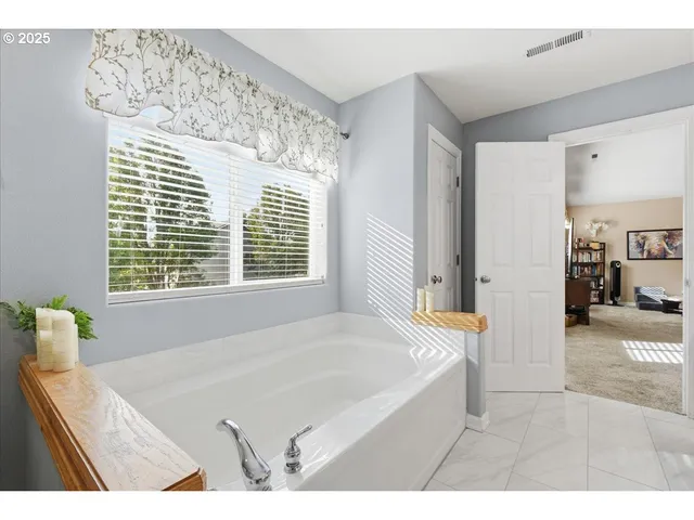 a bathroom with a tub sink and mirror