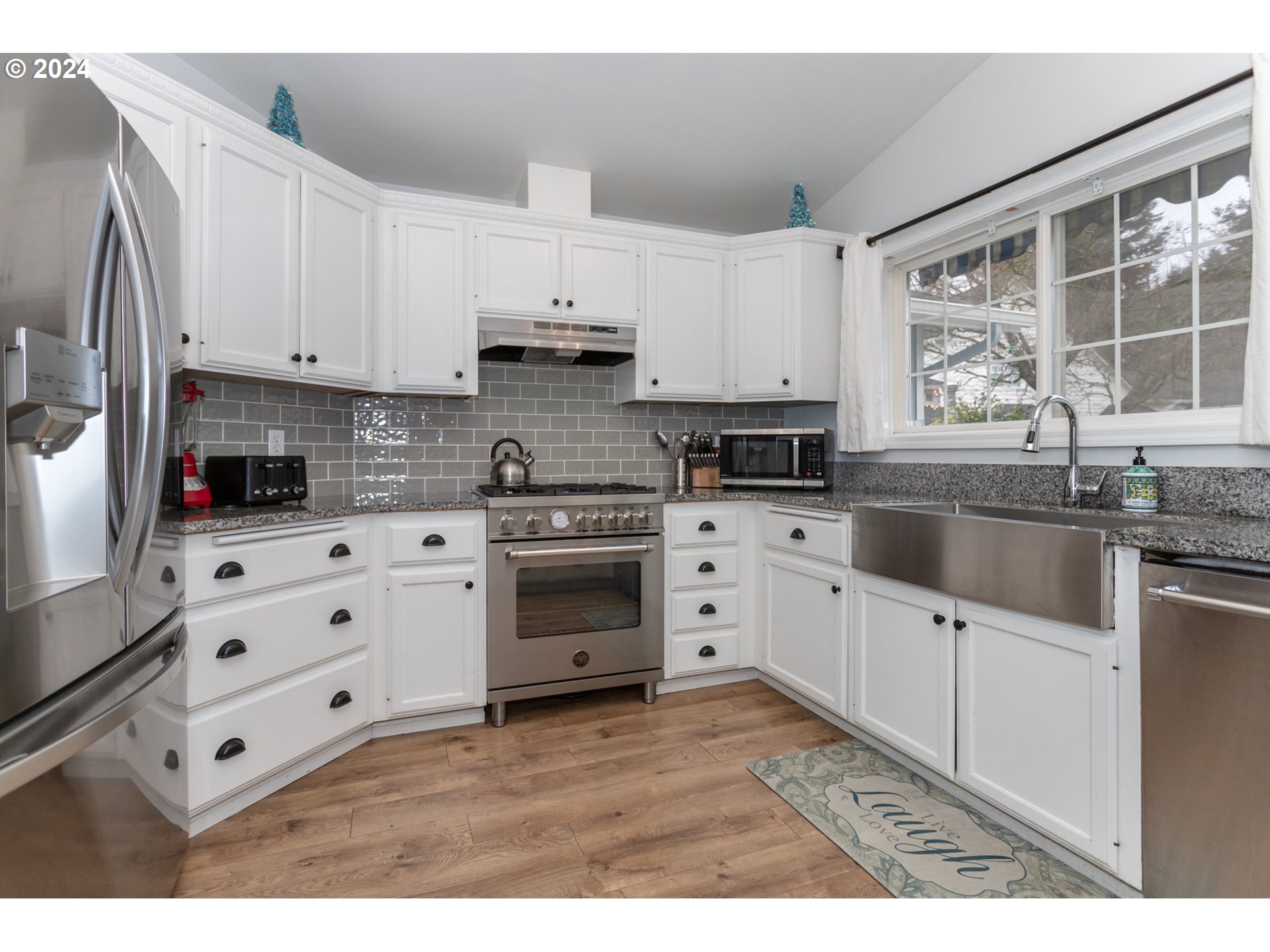 1690 Ridgley Boulevard Eugene, OR 97401 - Photo 11 of 30 a kitchen with granite countertop white cabinets white stainless steel appliances and sink