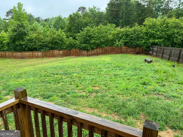 a view of a backyard with a wooden fence