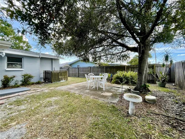 a view of a patio with table and chairs under an umbrella
