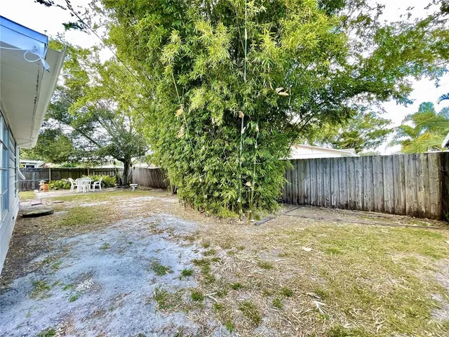 a view of a yard with an tree and wooden fence