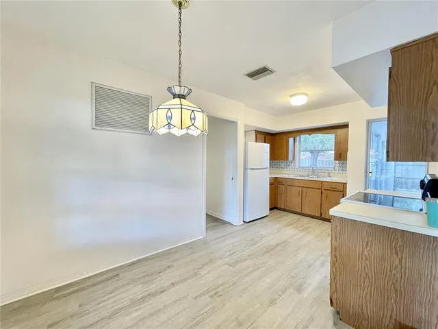 a view of a kitchen with a sink dishwasher a kitchen island a stove and a wooden floors