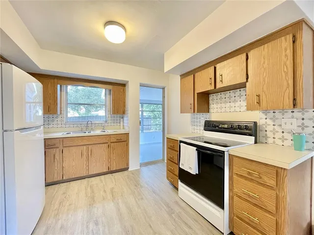 a kitchen with stainless steel appliances granite countertop a stove a sink and a refrigerator