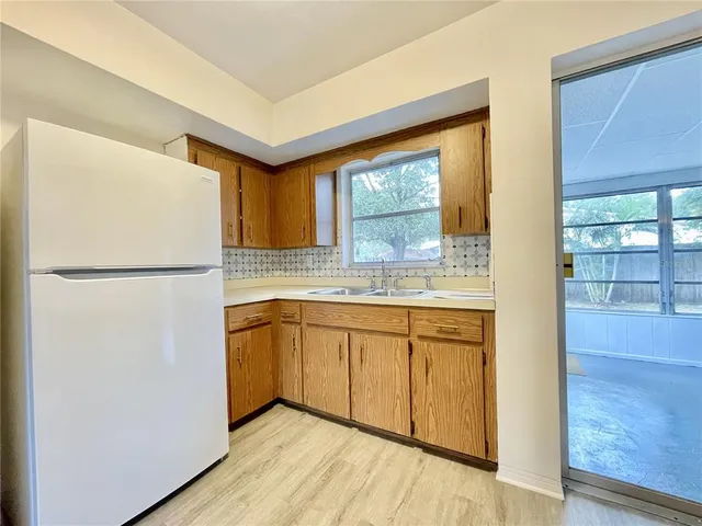 a kitchen with a refrigerator a sink and cabinets