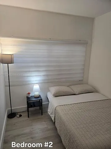 a bedroom with a bed and a lamp on table