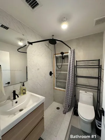 a bathroom with a toilet sink and shower