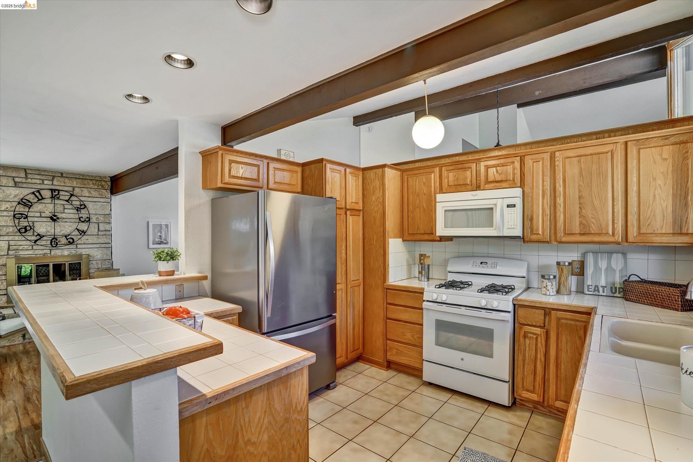 2826 Wright Avenue Pinole, CA 94564 - Photo 19 of 70 Kitchen featuring wood cabinetry, white tile countertops, and a white tile backsplash