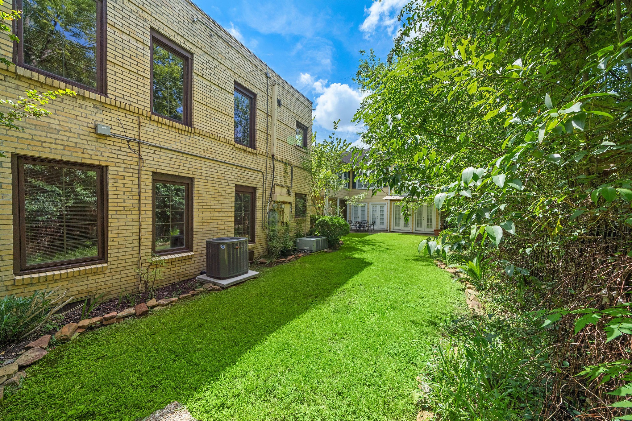 1801 Lexington Street Houston, TX 77098 - Photo 40 of 50 a view of a house with brick walls and a small yard with large tree