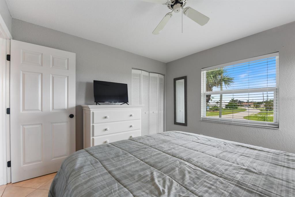 449 Royal Poinciana, Unit 221 Punta Gorda, FL 33955 - Photo 14 of 17 a bedroom with a bed and a flat screen tv