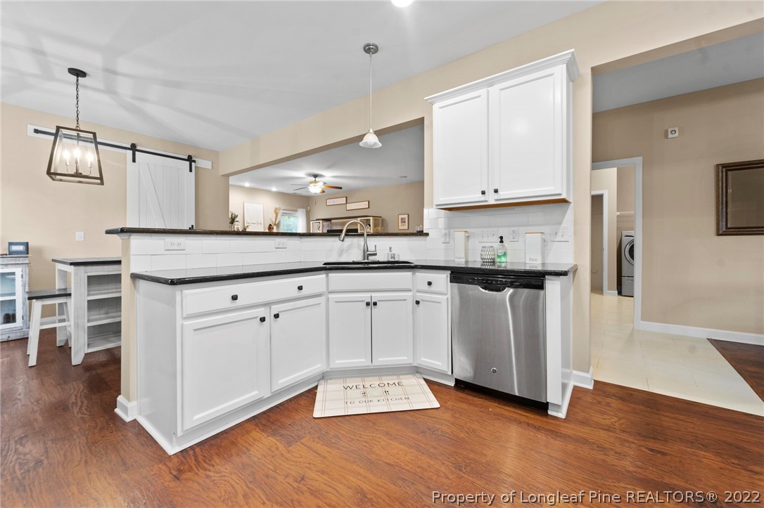 60 Shellbark Drive Spring Lake, NC 28390 - Photo 11 of 42 a kitchen with stainless steel appliances granite countertop a stove a sink and white cabinets with wooden floor