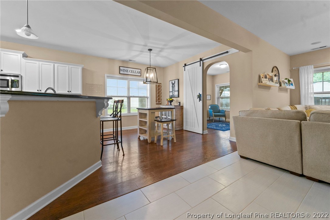 60 Shellbark Drive Spring Lake, NC 28390 - Photo 15 of 42 a kitchen with stainless steel appliances granite countertop a refrigerator a stove and a dining table with wooden floor